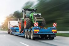 A Blue Lowboy Trailer Hauling a Farming Tractor on the Highway What Is the Lifespan of a Trailer
